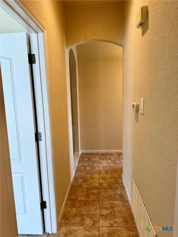 3508 Lucas St, Copperas Cove, TX 76522 - corridor featuring arched walkways, a textured wall, and tile patterned flooring