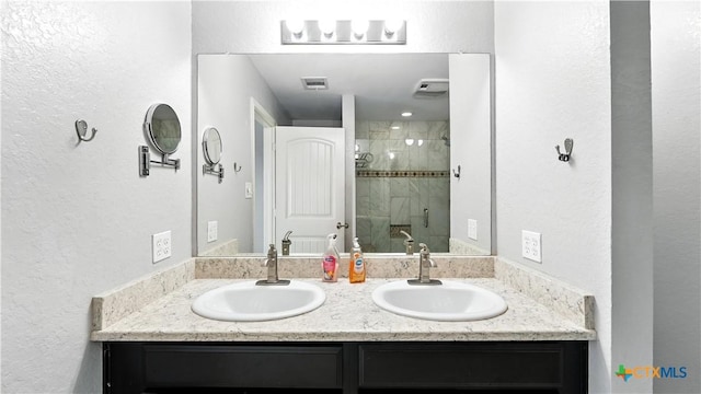 912 Bexley Dr, Seguin, TX 78155 - bathroom featuring a stall shower, double vanity, and a textured wall