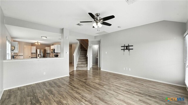 912 Bexley Dr, Seguin, TX 78155 - unfurnished living room with stairway, wood finished floors, ceiling fan, and healthy amount of natural light