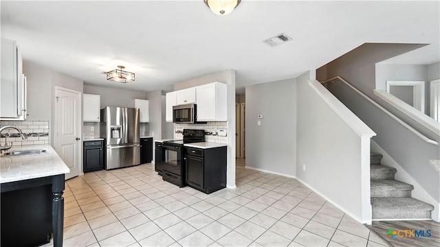 912 Bexley Dr, Seguin, TX 78155 - kitchen with stainless steel appliances, backsplash, white cabinets, and light tile patterned floors