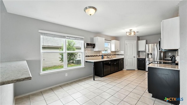 912 Bexley Dr, Seguin, TX 78155 - kitchen featuring black dishwasher, light countertops, backsplash, white cabinetry, and light tile patterned flooring