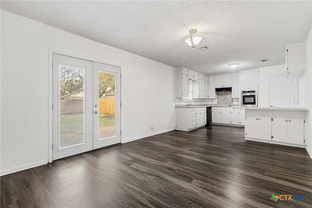 kitchen featuring a textured ceiling, white cabinetry, oven, and dark hardwood / wood-style floors