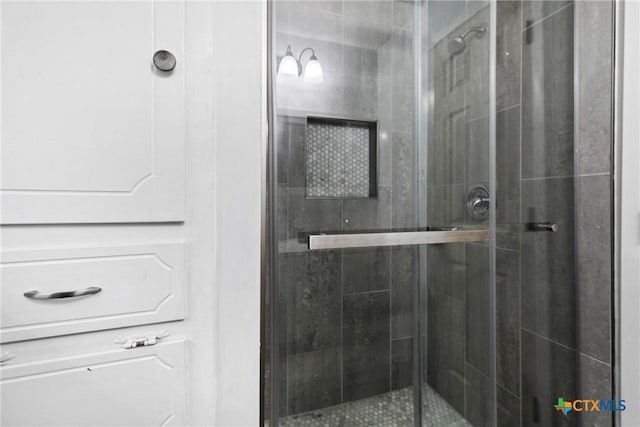 bathroom with a shower with door