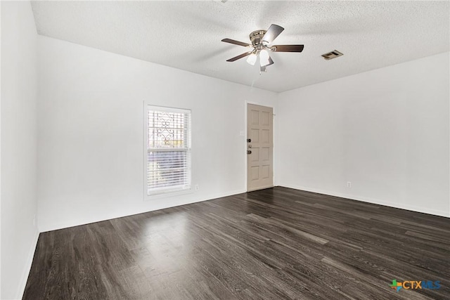 unfurnished room with a textured ceiling, ceiling fan, and dark wood-type flooring