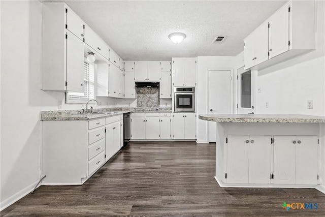 kitchen with white cabinets, oven, sink, a textured ceiling, and dark hardwood / wood-style flooring