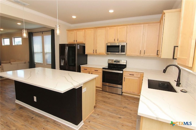 kitchen featuring a kitchen island, light stone countertops, sink, and appliances with stainless steel finishes