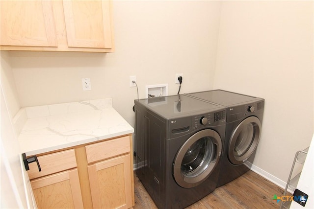 laundry room featuring cabinets, dark hardwood / wood-style floors, and washer and clothes dryer