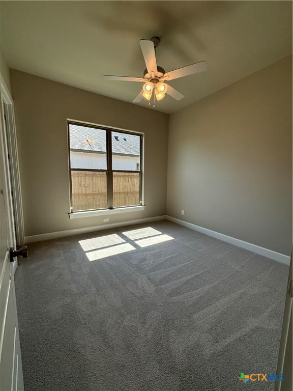 empty room featuring carpet flooring, ceiling fan, and baseboards