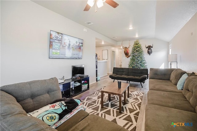 living room featuring ceiling fan, vaulted ceiling, and wood-type flooring