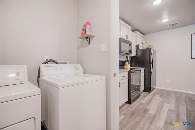 washroom featuring washing machine and dryer and light wood-type flooring