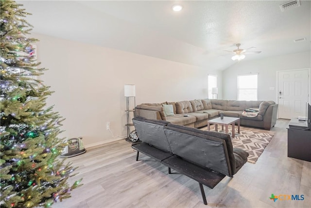 living room featuring lofted ceiling, ceiling fan, and light hardwood / wood-style floors