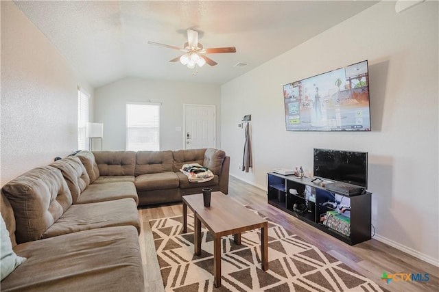 living room with vaulted ceiling, ceiling fan, and light hardwood / wood-style flooring