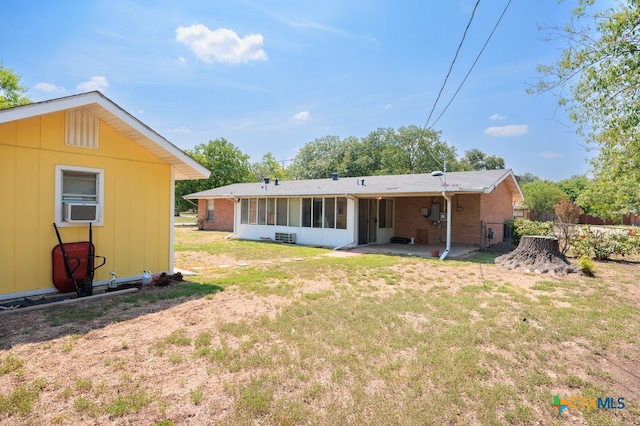 rear view of house with a sunroom, a yard, cooling unit, and a patio area