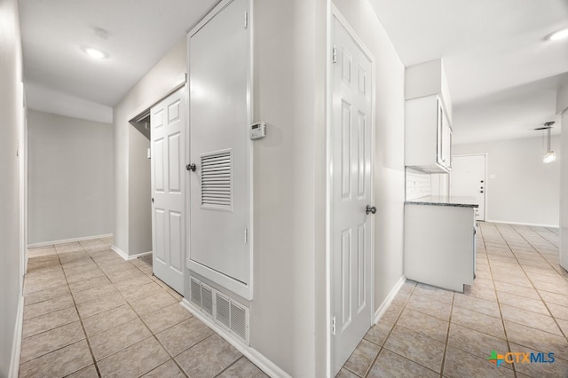 corridor featuring light tile patterned floors