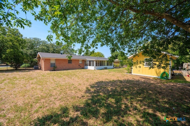 view of yard featuring central AC and a sunroom