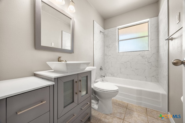 full bathroom with tile patterned flooring, vanity, tiled shower / bath combo, and toilet