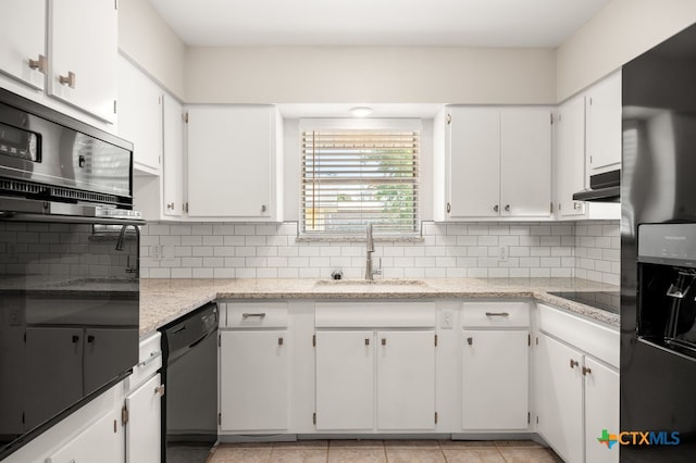 kitchen featuring backsplash, white cabinetry, sink, and black appliances