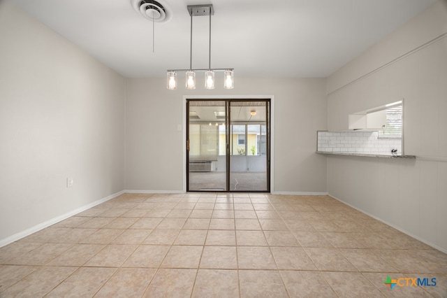 spare room featuring a wealth of natural light and light tile patterned flooring