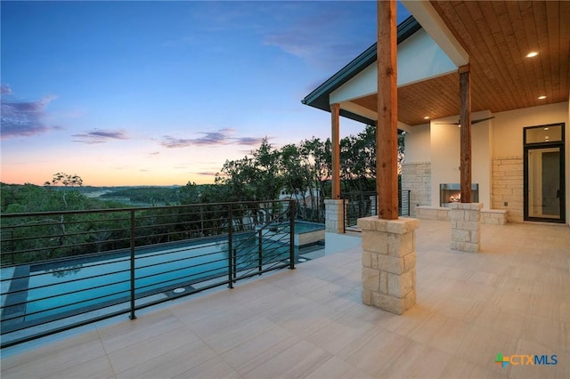 patio terrace at dusk with an outdoor stone fireplace