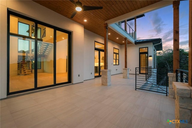 patio terrace at dusk featuring ceiling fan