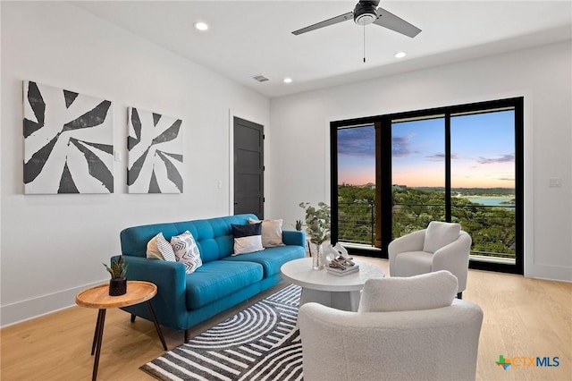 living room with ceiling fan and light hardwood / wood-style floors