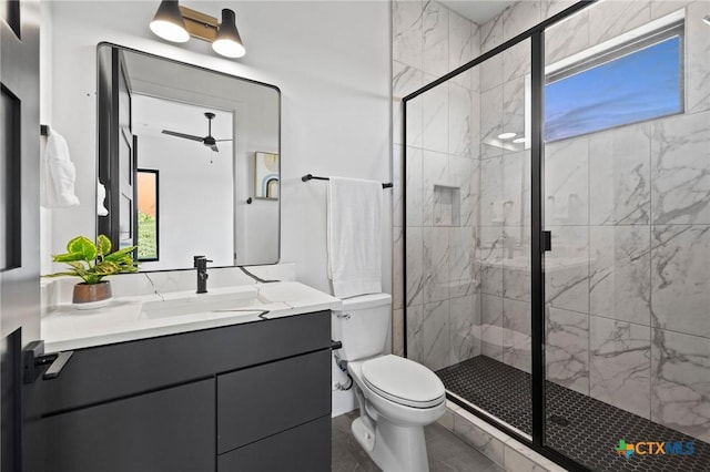 bathroom with vanity, toilet, an enclosed shower, and ceiling fan