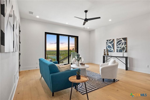 living room with ceiling fan and light hardwood / wood-style floors