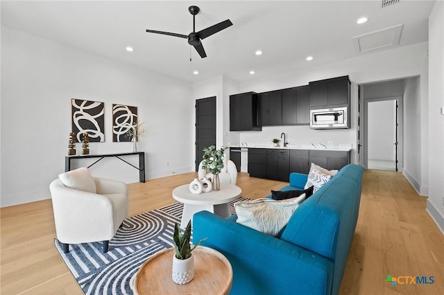 living room featuring ceiling fan and light hardwood / wood-style flooring