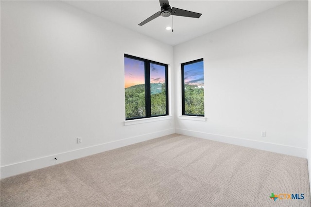 carpeted spare room featuring ceiling fan