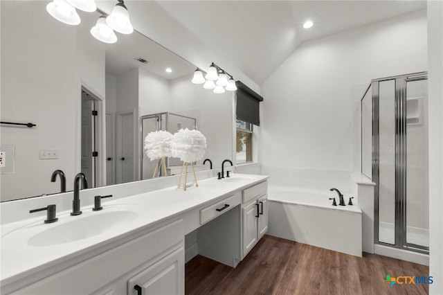 bathroom featuring plus walk in shower, vanity, wood-type flooring, and vaulted ceiling