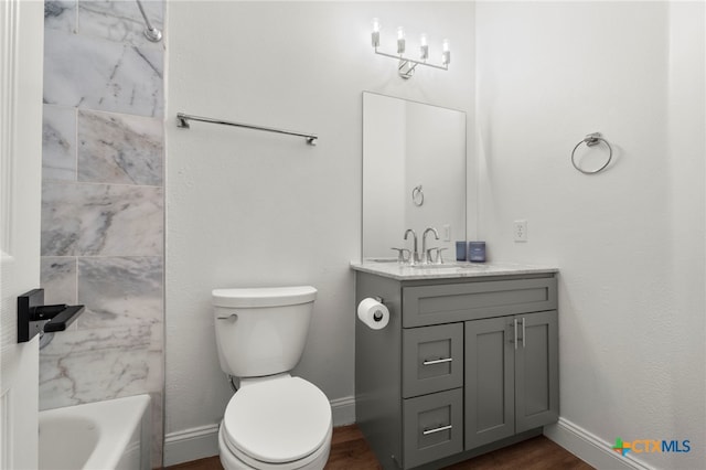 full bathroom featuring wood-type flooring, vanity, toilet, and tiled shower / bath