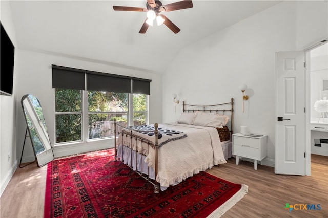 bedroom featuring lofted ceiling, multiple windows, and hardwood / wood-style flooring