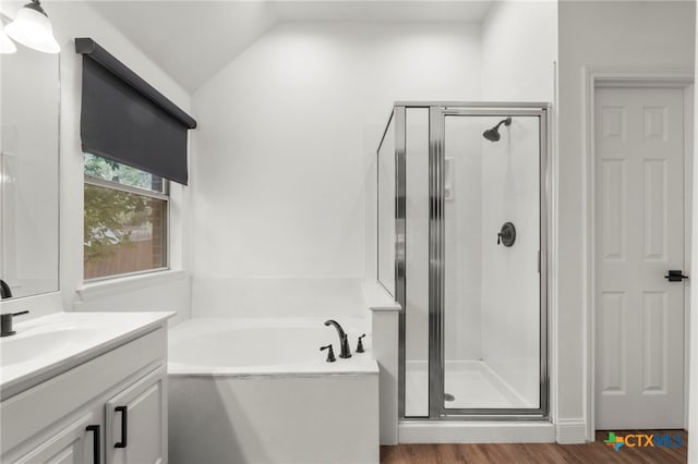 bathroom with hardwood / wood-style flooring, vanity, shower with separate bathtub, and vaulted ceiling