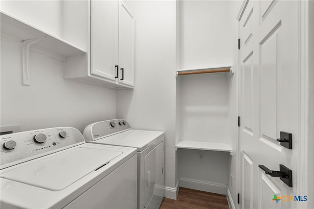 washroom featuring washing machine and dryer, cabinets, and dark wood-type flooring