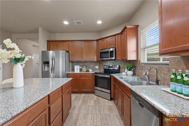 2226 Hayes St, Temple, TX 76502 - kitchen with appliances with stainless steel finishes, brown cabinets, decorative backsplash, and recessed lighting