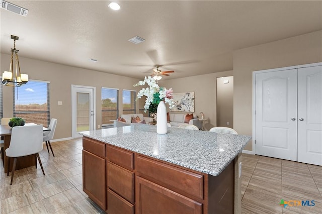 2226 Hayes St, Temple, TX 76502 - kitchen featuring a ceiling fan, a chandelier, light tile patterned floors, and a kitchen island