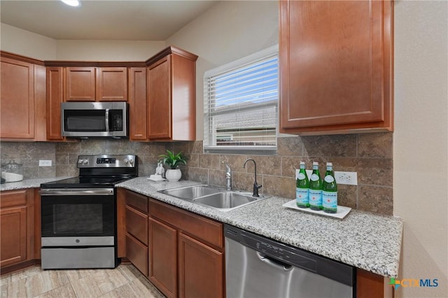 2226 Hayes St, Temple, TX 76502 - kitchen with appliances with stainless steel finishes, light countertops, tasteful backsplash, and brown cabinetry