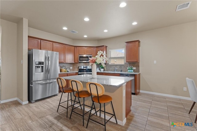 2226 Hayes St, Temple, TX 76502 - kitchen featuring stainless steel appliances, tasteful backsplash, a kitchen bar, a center island, and recessed lighting