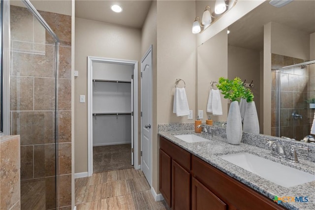 2226 Hayes St, Temple, TX 76502 - full bathroom with a stall shower, double vanity, a walk in closet, and recessed lighting