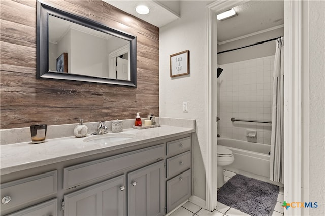 full bath featuring wooden walls, toilet, shower / tub combo with curtain, tile patterned flooring, and vanity