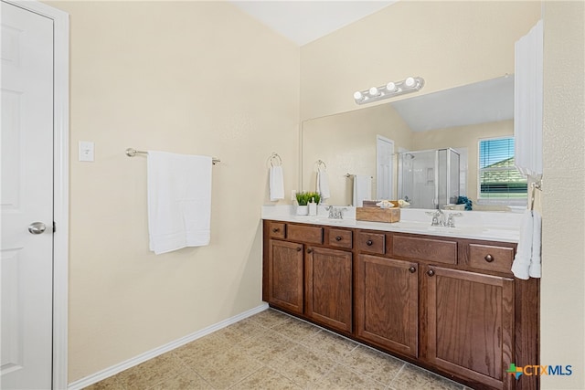 bathroom with tile patterned floors, vanity, a shower with shower door, and lofted ceiling