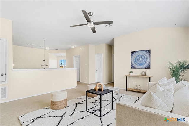 carpeted living room with ceiling fan and vaulted ceiling