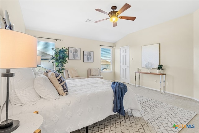 carpeted bedroom featuring multiple windows, ceiling fan, and vaulted ceiling