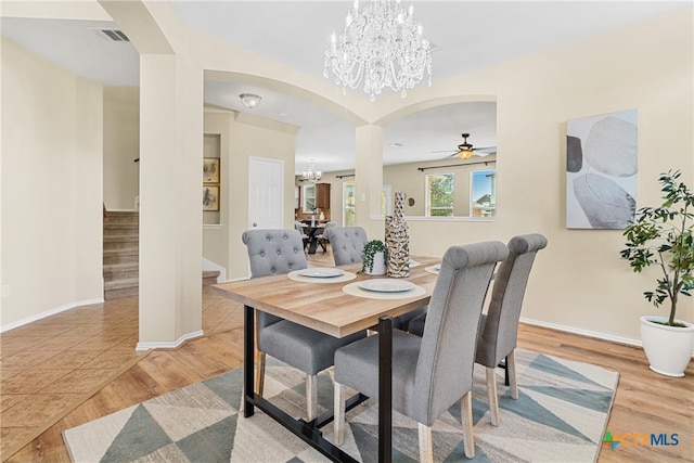 dining room with light hardwood / wood-style floors and ceiling fan with notable chandelier