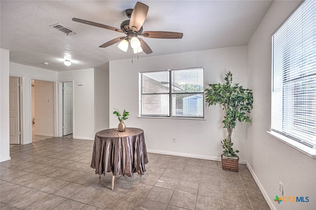 tiled empty room with ceiling fan