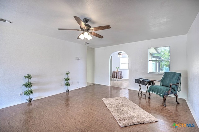 sitting room with ceiling fan, wood-type flooring, and a textured ceiling