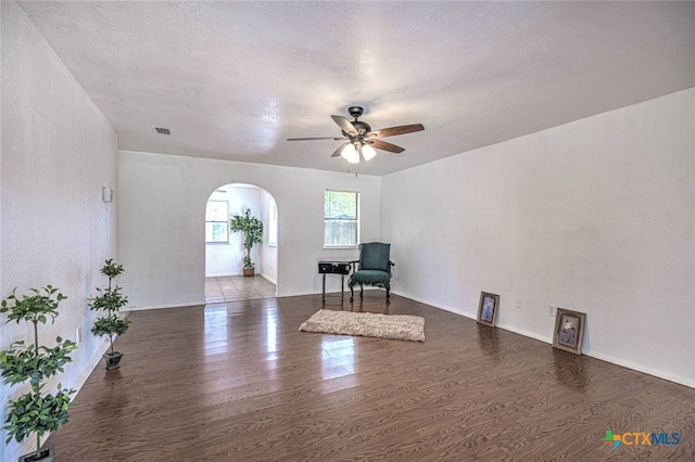 unfurnished room featuring dark wood-type flooring, a textured ceiling, and ceiling fan