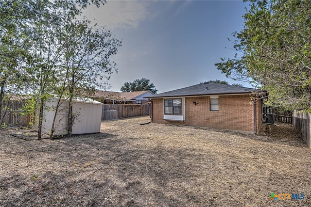 rear view of property featuring a storage shed