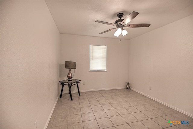 tiled spare room featuring ceiling fan