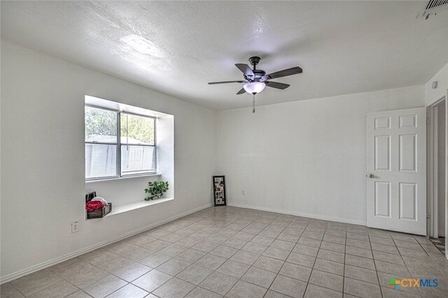 unfurnished room featuring a textured ceiling, light tile patterned floors, and ceiling fan